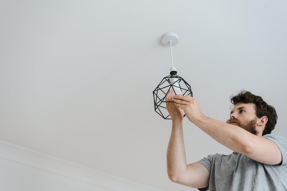 man checking light bulb